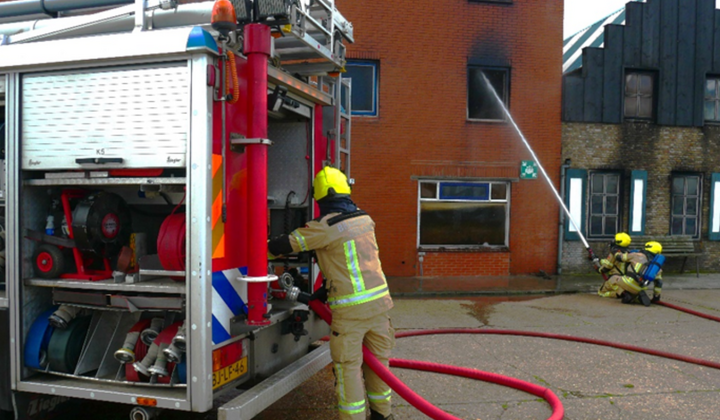 Pompbediener zorgt voor water tijdens blussen brand
