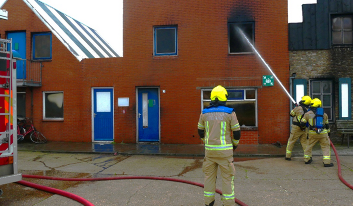 Een instructeur van de brandweer geeft les aan nieuwe brandweervrijwilligers op